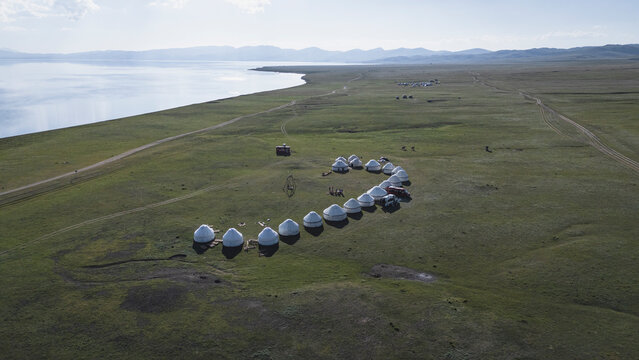 Sweeping aerial view of a yurt encampment by a lake