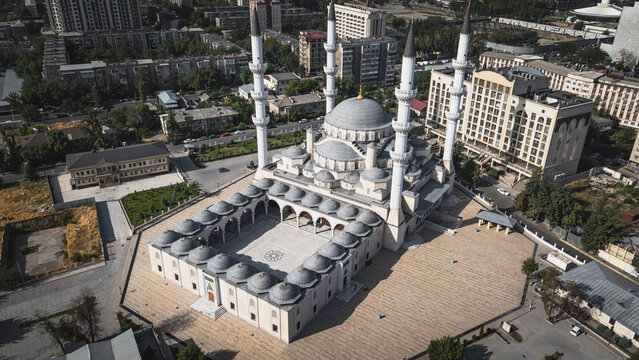 Aerial view of a grand mosque in a dense urban cityscape