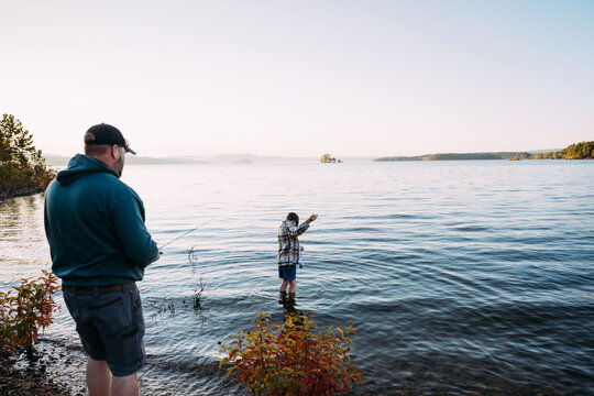 Boy Untangles Dads Fishing Line In Lake