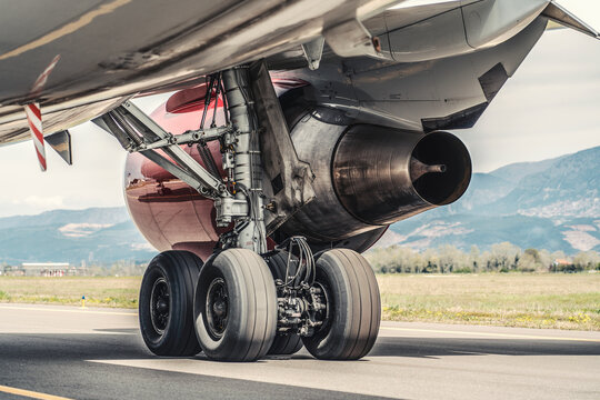 Close up of airplane landing gear and engine on ramp