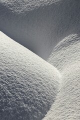 Minimalist snow drift waves creating natural abstract pattern of dunes with sharp contrast shadows © Nazar