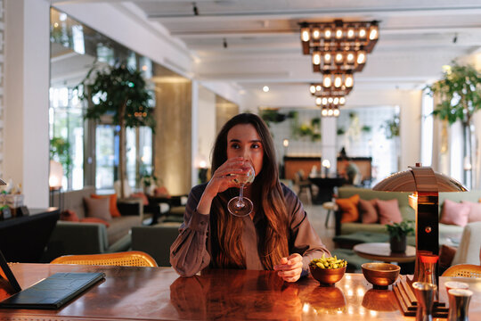 Woman drinks wine at a luxury hotel bar