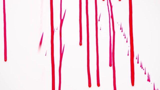 closeup of blood or paint dripping on white. Shot of Red Blood Flowing in Thin Streams on a Clean White Background. High-Speed Liquid Detail for Medical, Horror or Dramatic Visual Concepts.