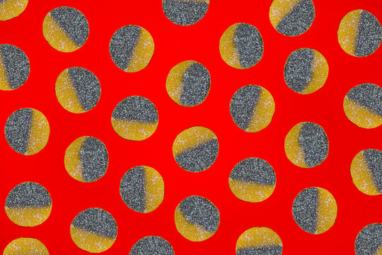 Sour gummy candy forms a pattern on a red background