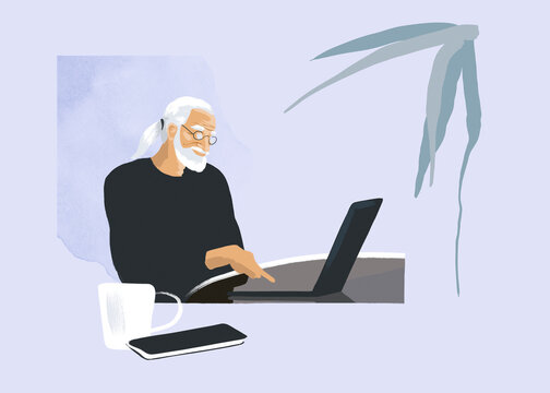 A senior freelance man works on a laptop at his home desk