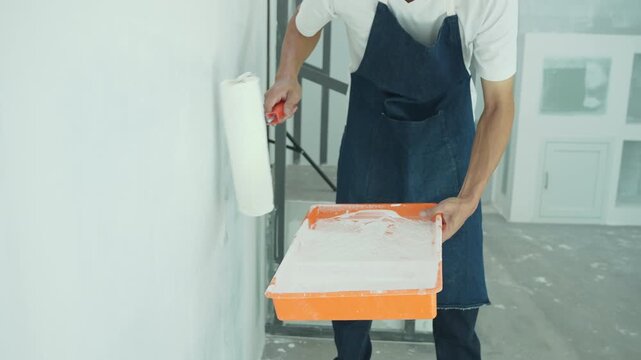 painter man, brush in hand for products to restore and paint the wall, indoor the building site of a house, wall during painting, renovation, painting, contractor, Architect, construction w