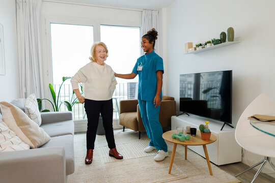 Nurse helping elderly with exercise therapy at home