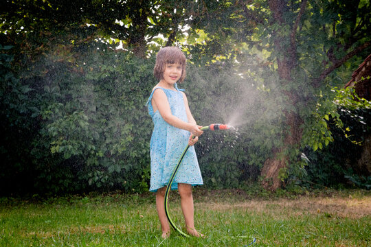 Little girl with garden hose