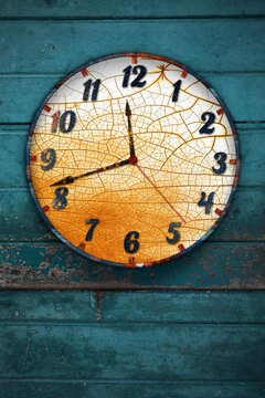 Old weathered clock hanging on a blue wooden wall