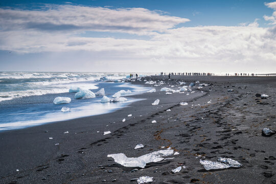Glacial ice chunks rest on the black volcanic sand of Diamond Beach