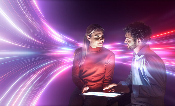 Man and woman analyze AI data on a tablet in the office