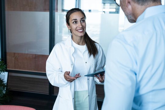 Female doctor with tablet advises male patient in the office