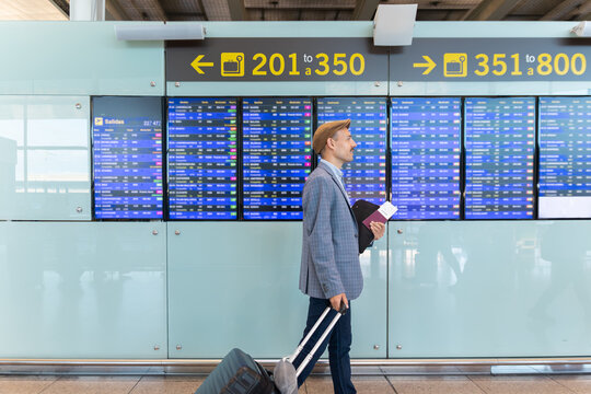 Male passenger walking with luggage at Barcelona airport terminal