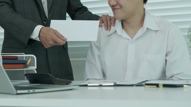 Businessmen receive salary or bonuses from management or Boss. Company give rewards to encourage work. Smiling businessman enjoying a reward at the desk in the office.