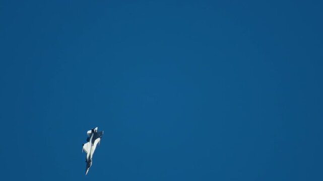 Military F16 fighter jet performing aerobatic maneuvers