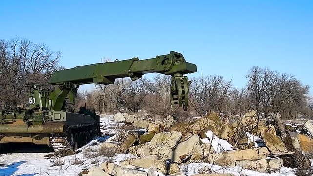Military tracked vehicle of the engineering troops, clears rubble, carries large logs, concrete beams and building elements.