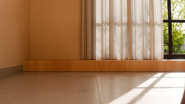 Empty sunlit room with tiled floor and window curtains