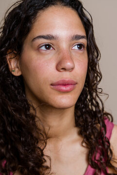 Hispanic woman with curly hair and freckles