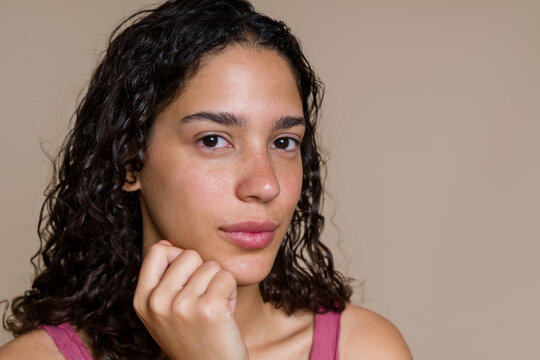 Portrait of a young Hispanic adult woman with curly hair and natural