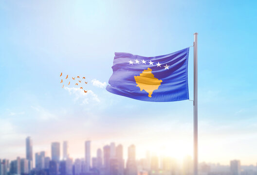 Kosovo national flag waving with skyline and buildings. Kosovo national flag for independence day.