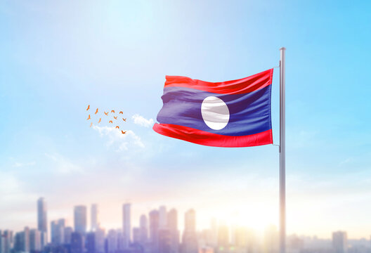 Laos national flag waving with skyline and buildings. Laos national flag for independence day.