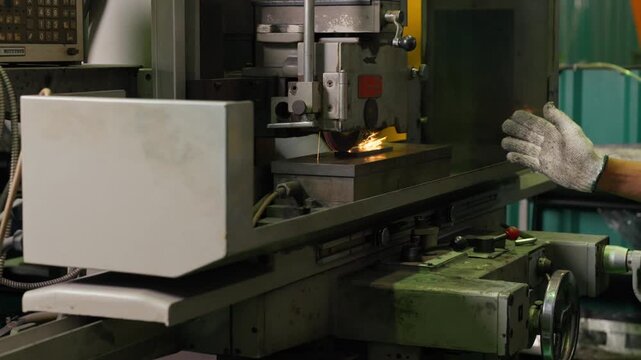 Factory Worker Operating Industrial Surface Grinding Machine in Workshop
