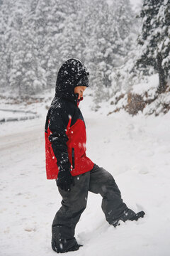 Boy walking through deep snow during heavy snowfall