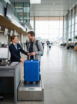 Passenger checking in luggage at airport counter