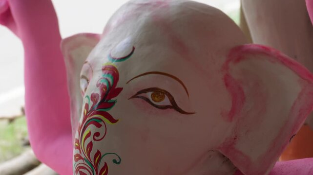 artisan painting a traditional clay Ganesh idol by hand