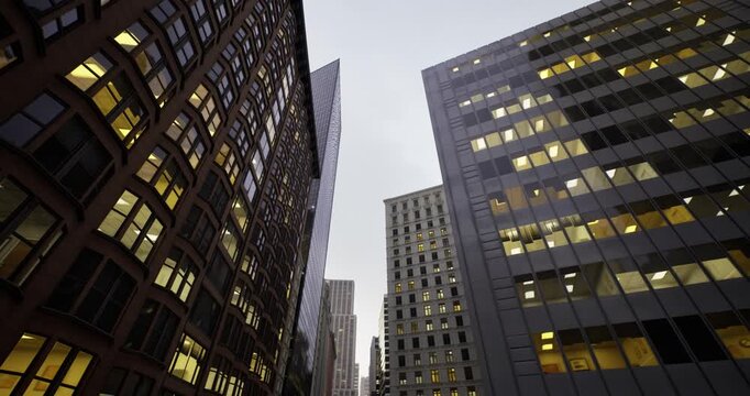 Contemporary structures cast reflections across thoroughfare, Urban high rises with gleaming surfaces create striking contrast along slender street