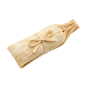 One isolated tamale in corn husk, tied with straw, on transparent background. Traditional food.