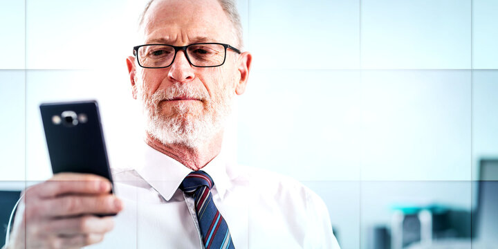 Portrait of senior businessman looking at his mobile phone, geometric pattern