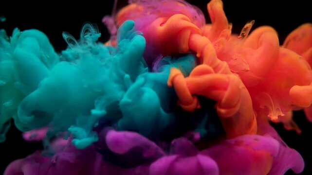 Colorful ink drops exploding in water with vibrant clouds of pigment swirling and mixing in slow motion for artistic abstract video backgrounds