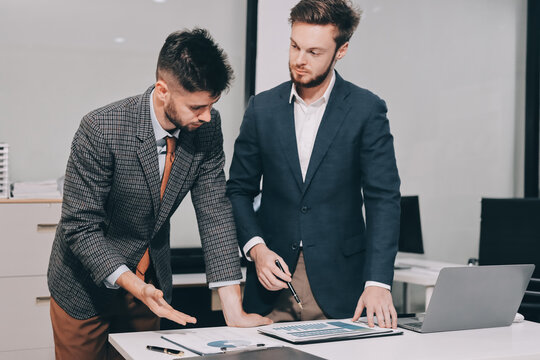 Business team collaborating on digital data analysis in modern office