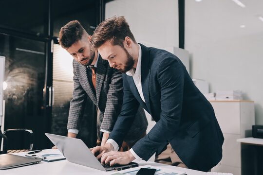 Business team collaborating on digital data analysis in modern office