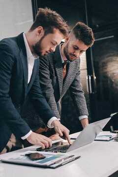 Business team collaborating on digital data analysis in modern office
