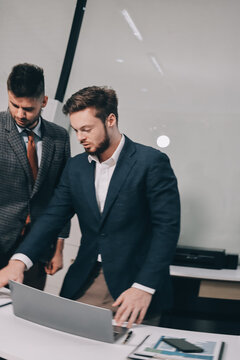 Business team collaborating on digital data analysis in modern office