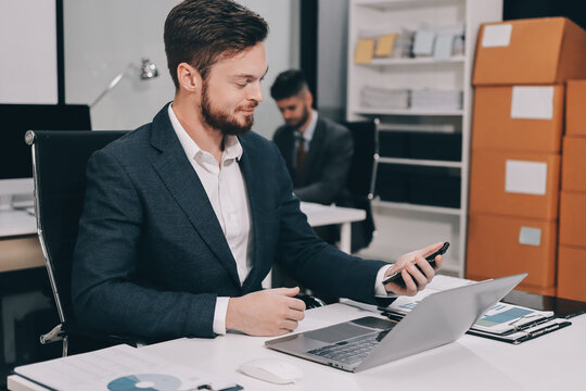 Two partners, team of professional business people working, discussing, writing notes at desk. Mature focused senior mentor leader man showing young woman manager project on laptop in modern office