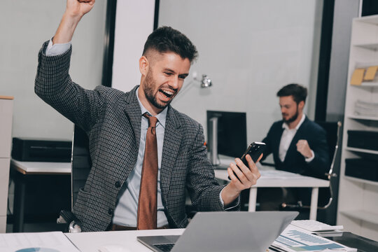 Two partners, team of professional business people working, discussing, writing notes at desk. Mature focused senior mentor leader man showing young woman manager project on laptop in modern office