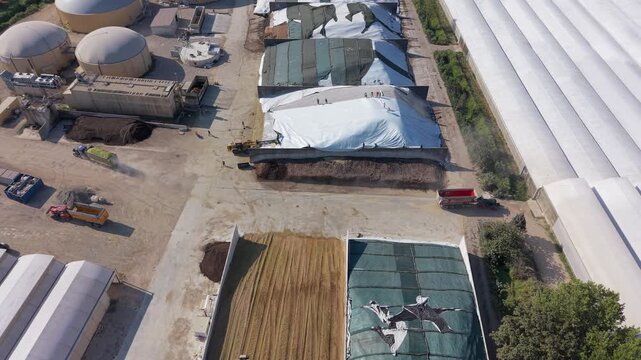 Aerial daytime view of covered silage pits filled with stored livestock feed at a cattle farm in Lombardy, Italy. 
