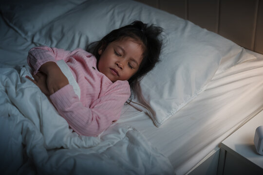preschool child girl sleeping on bed at night