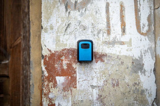 Lock box with key code inside located on wall near entrance gate at apartment building, booking accommodation online during traveling. Special key box placed on wall for rental flats.
