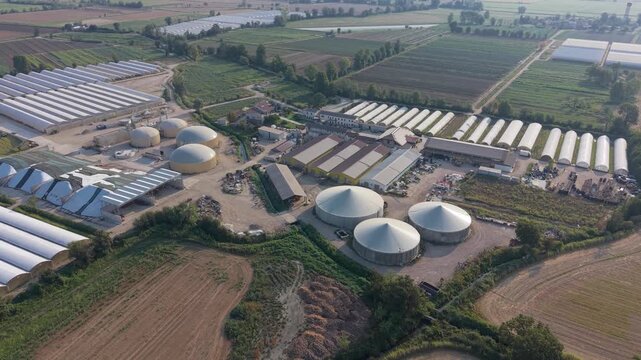 Aerial view of an agricultural complex featuring anaerobic digesters for biomethane production alongside farming facilities, illustrating renewable energy generation from agricultural resources.