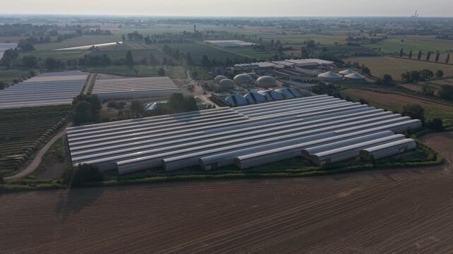 Aerial view of a large agricultural complex in northern Italy combining commercial greenhouses, livestock farming and industrial facilities, illustrating modern integrated agricultural production.