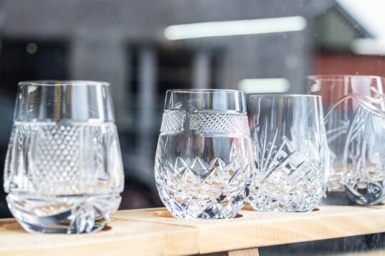Vibrant decorative drinking glasses with carved circular patterns sitting on light wood blocks