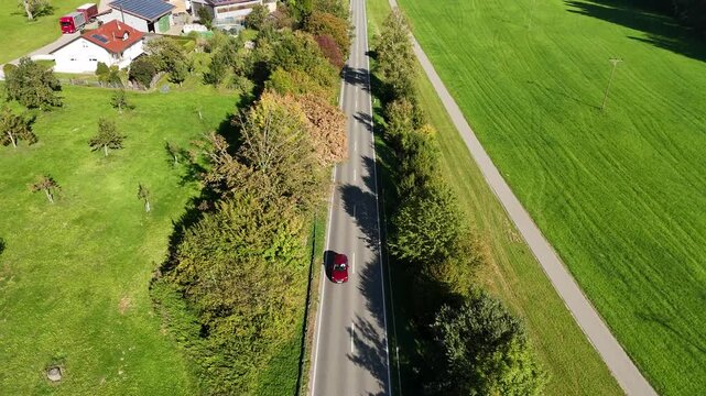 Aerial View Along Highway Traffic in Southern Germany. Drone aerial shot moving forward along a highway with driving cars, green fields, and trees near Amtzell between Ravensburg and Wangen in souther