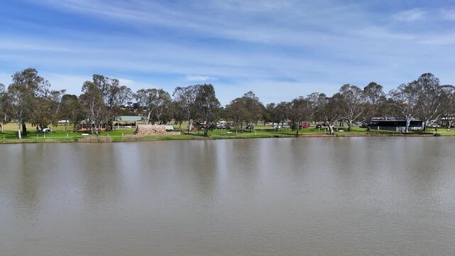 Murray River and the opposite riverbank at Sturt Reserve in Murray Bridge, South Australia, lined with lush green grass, gum trees, and park facilities. Riverfront reserve and regional parkland