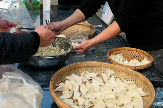 A group of people are making dumplings during traditional festivals