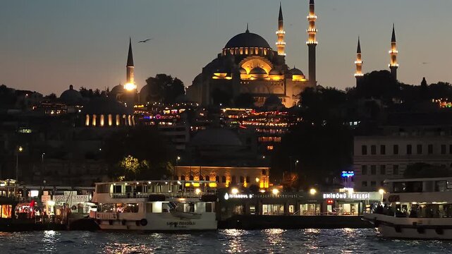 Cityscape View of Bosporus and Illuminated Mosque Neuve in Istanbul at Night. High quality 4k footage