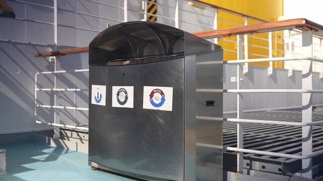 Waste sorting bin on a cruise ship deck against white railings